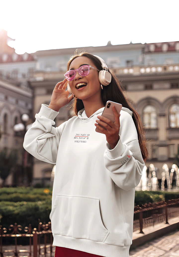 With her headphones on, the woman in the white hoodie immerses herself in the music, fashioning a memory of serene enjoyment and contemporary style.