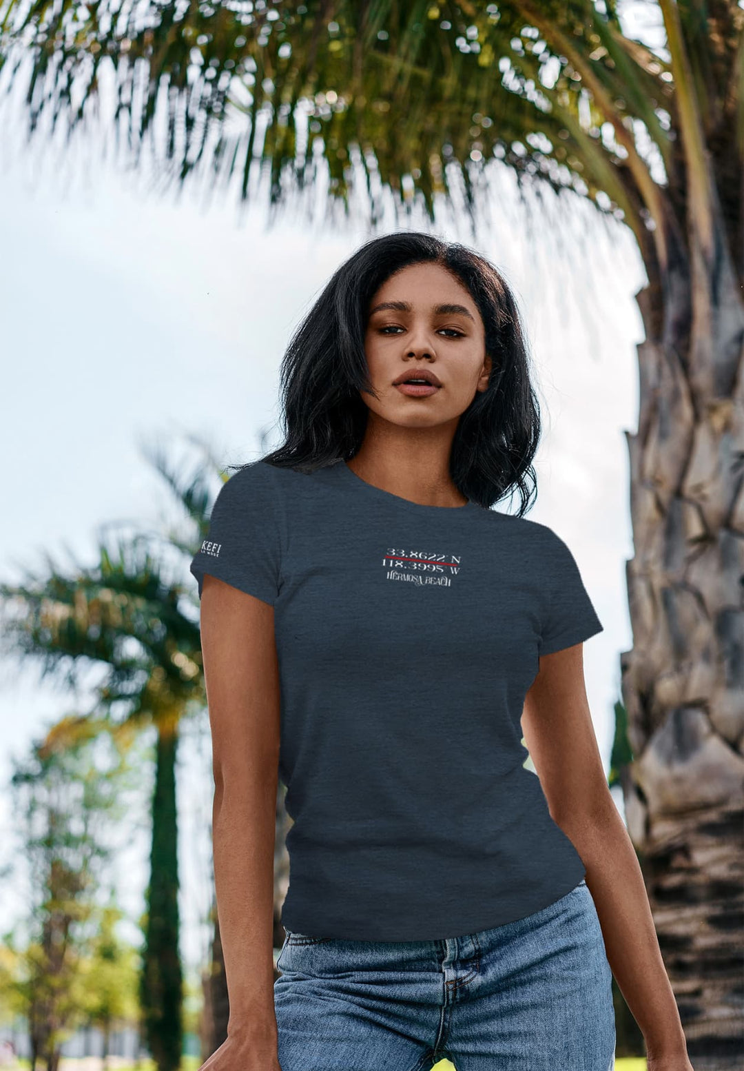 The woman poses confidently in her blue t-shirt. This perfect blend of style and nature reflects the essence where fashion captures the spirit of carefree beauty.