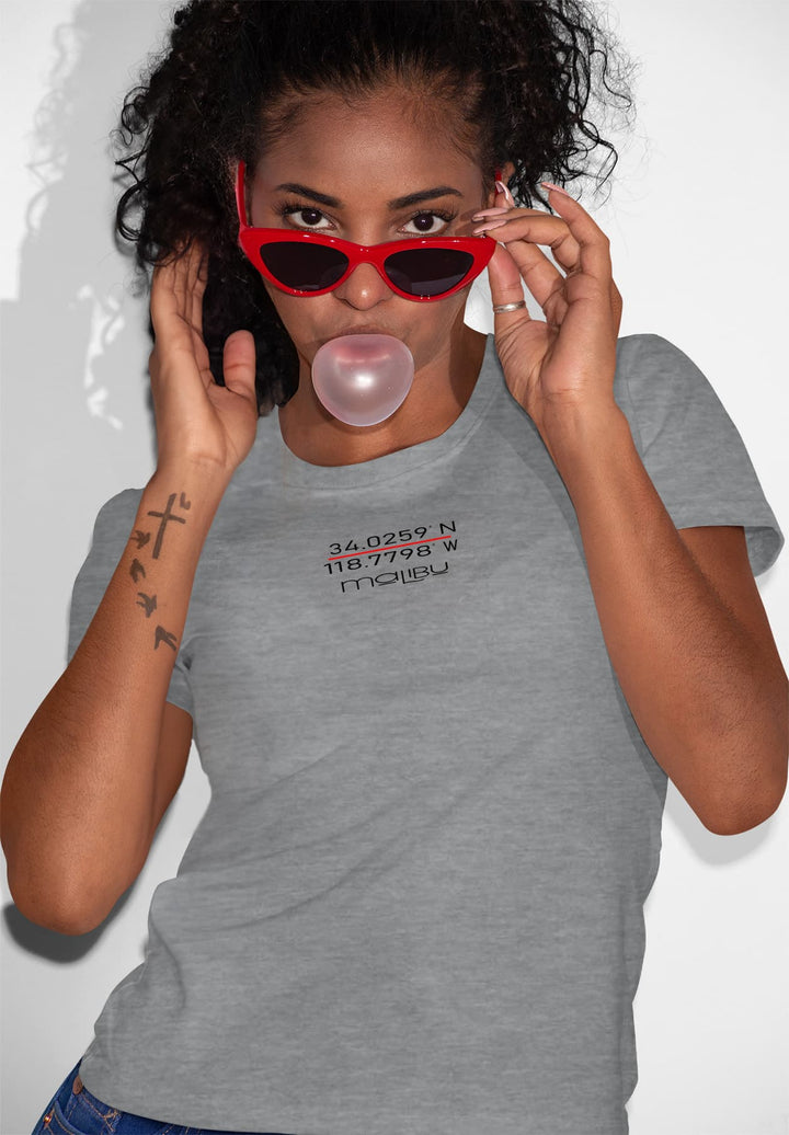 A woman strikes a pose with a bubble, dressed in a comfortably chic gray t-shirt, embodying carefree joy and childlike wonder.