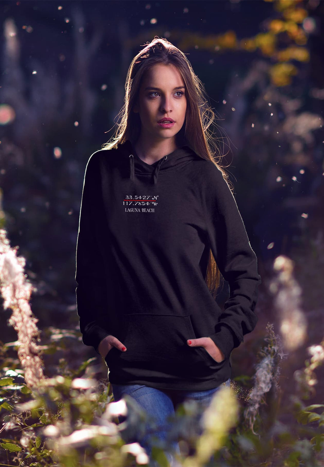 Standing in the field, the woman in the black hoodie creates a fashion moment that fuses urban style with the tranquility of nature.