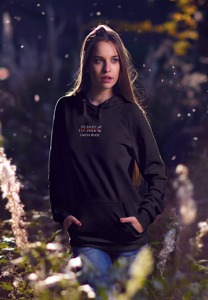 Standing in the field, the woman in the black hoodie creates a fashion moment that fuses urban style with the tranquility of nature.