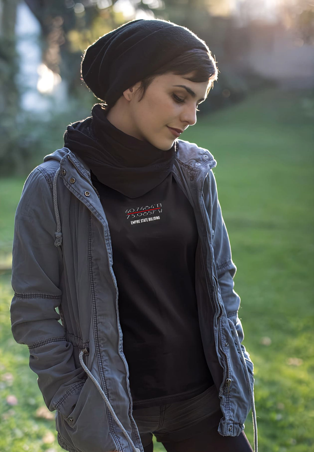 Effortless chic woman stands, captured in a black tee and gray jacket, a blend of style and moments.