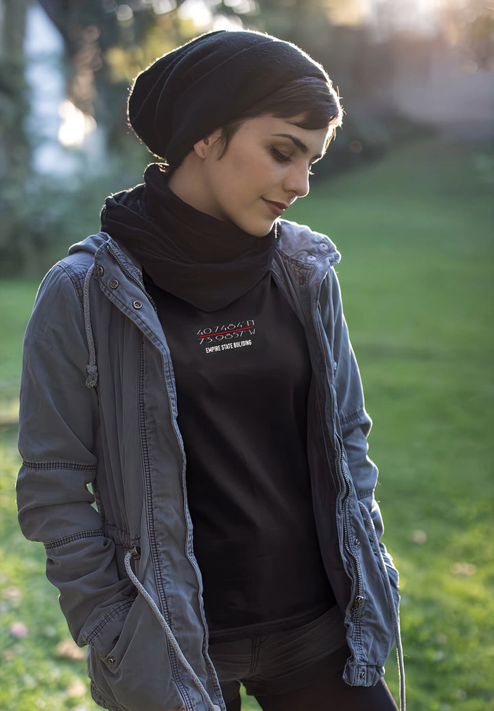 Effortless chic woman stands, captured in a black tee and gray jacket, a blend of style and moments.