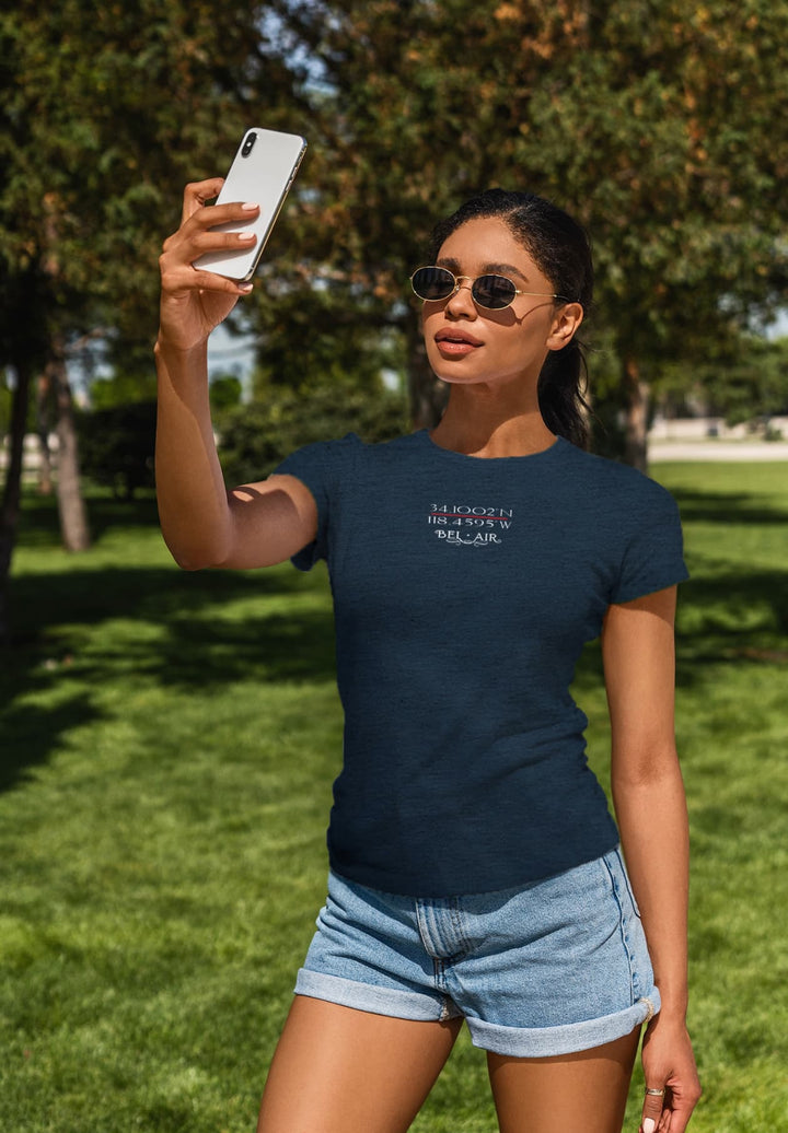  Capturing a moment of carefree joy, the woman stands, in the gentle hue of a blue T-shirt, as she takes a selfie, spreading spontaneity and genuine happiness.