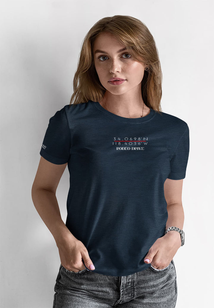 In a casual elegance, a woman stands gracefully in a blue T-shirt paired with gray jeans, embodying a relaxed yet stylish charm.