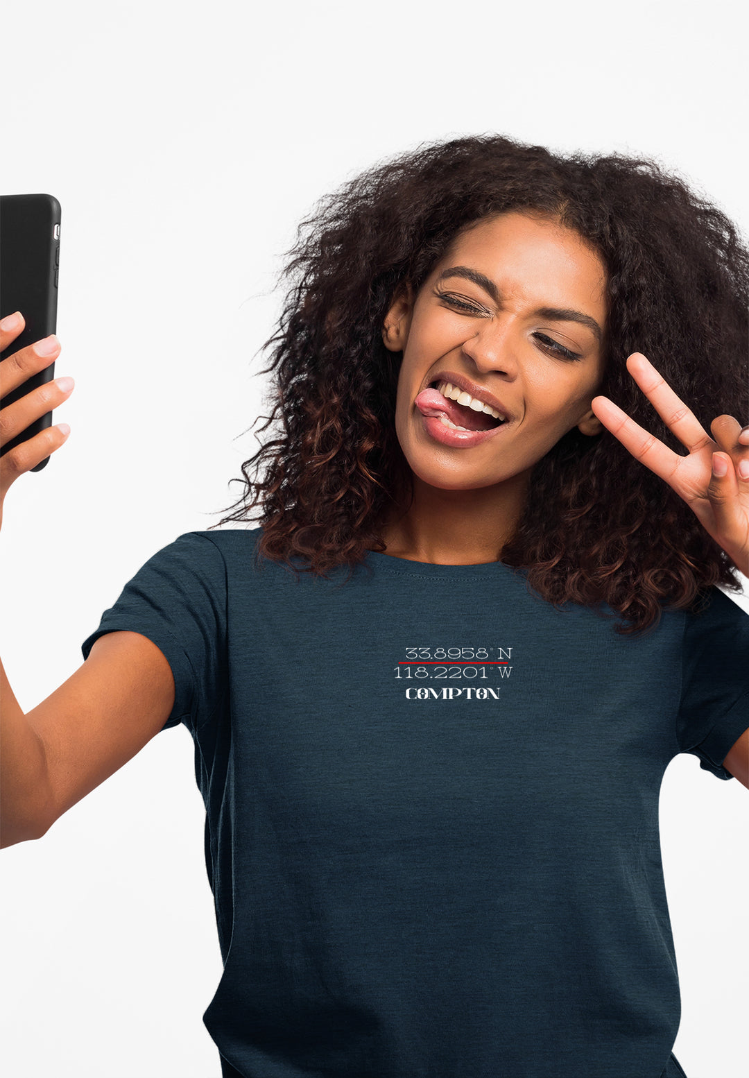 Capturing a moment of self-expression, a woman wears a blue t-shirt while taking a selfie, expressing playful confidence and a reflection of her emotional connection to the present.