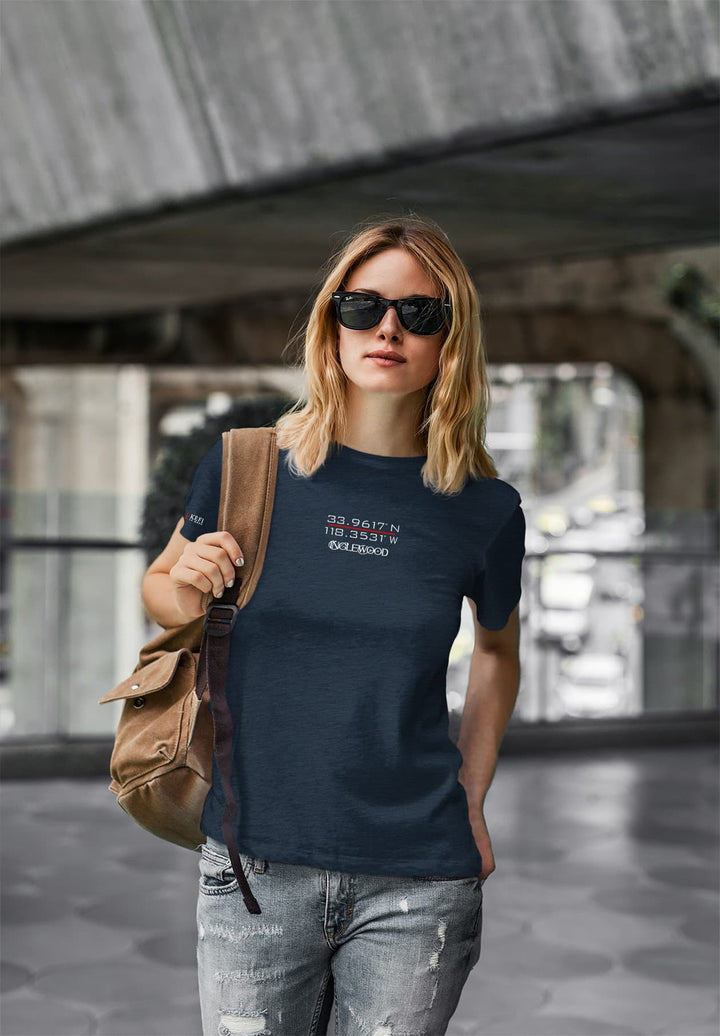 a woman strides with effortless style, adorned in a vibrant blue t-shirt and chic sunglasses, radiating a confident and carefree aura.