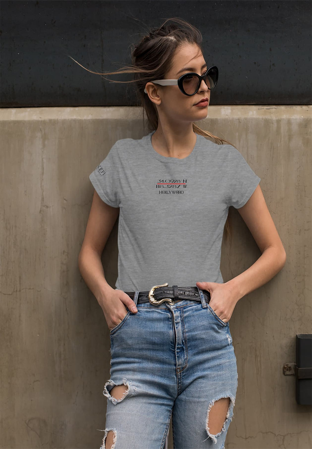 Wearing a gray t-shirt and fashionable ripped jeans, a woman captures an effortless blend of casual charm and trendy allure.