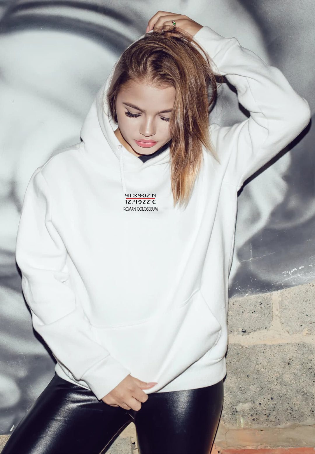 In a relaxed moment, the woman stands out in a white hoodie and black leggings.