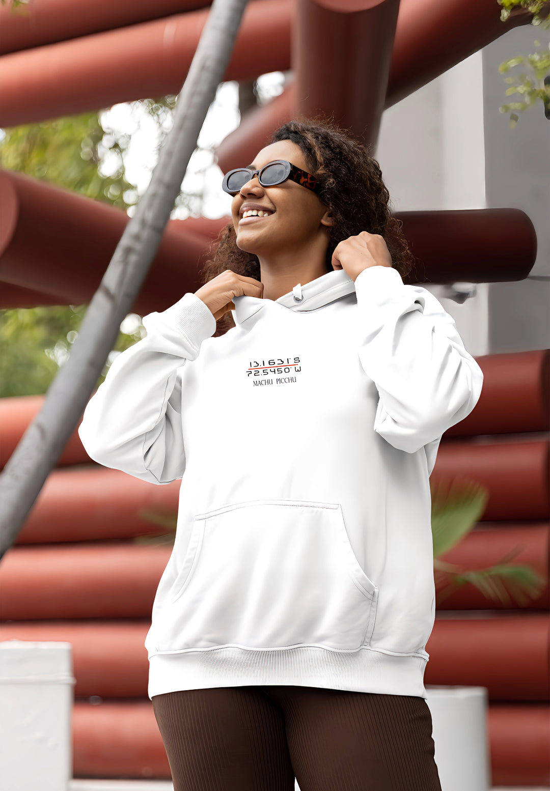 Embracing the spirit of adventure, the woman's outfit of a white pullover Machu Picchu hoodie and sunglasses captures a moment of cultural appreciation.