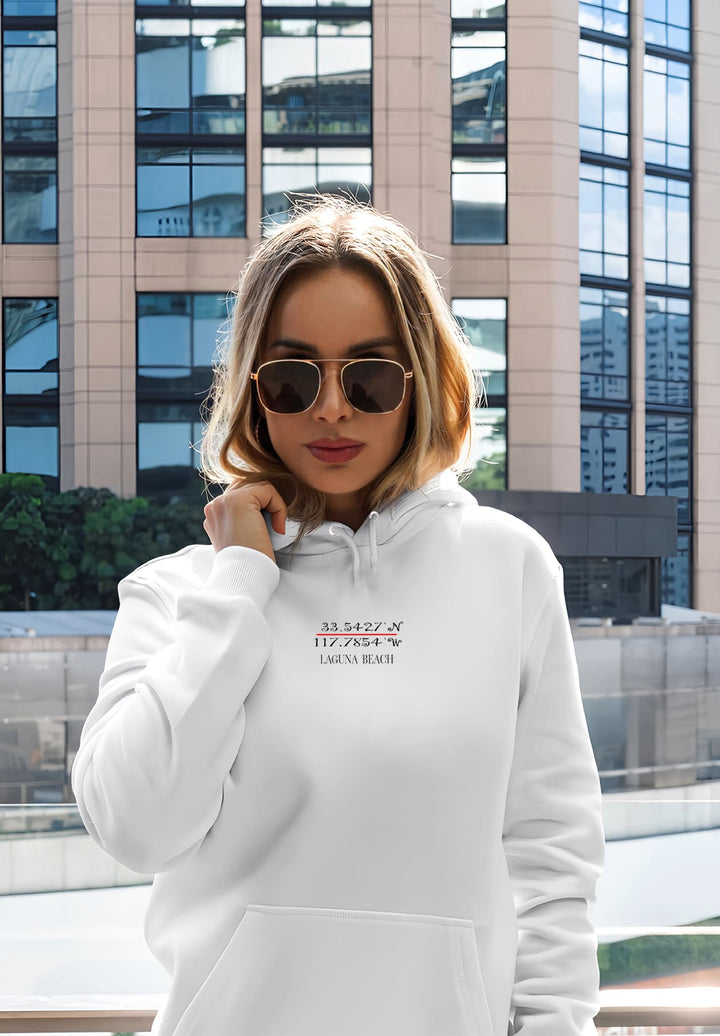 With her sunglasses on, the woman wearing a white hoodie exudes a sense of urban coolness and timeless style.