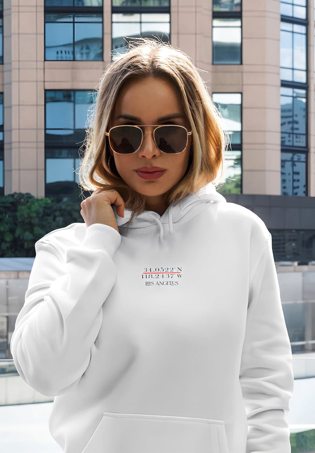 The white hoodie and sunglasses give a casual, trendy look.