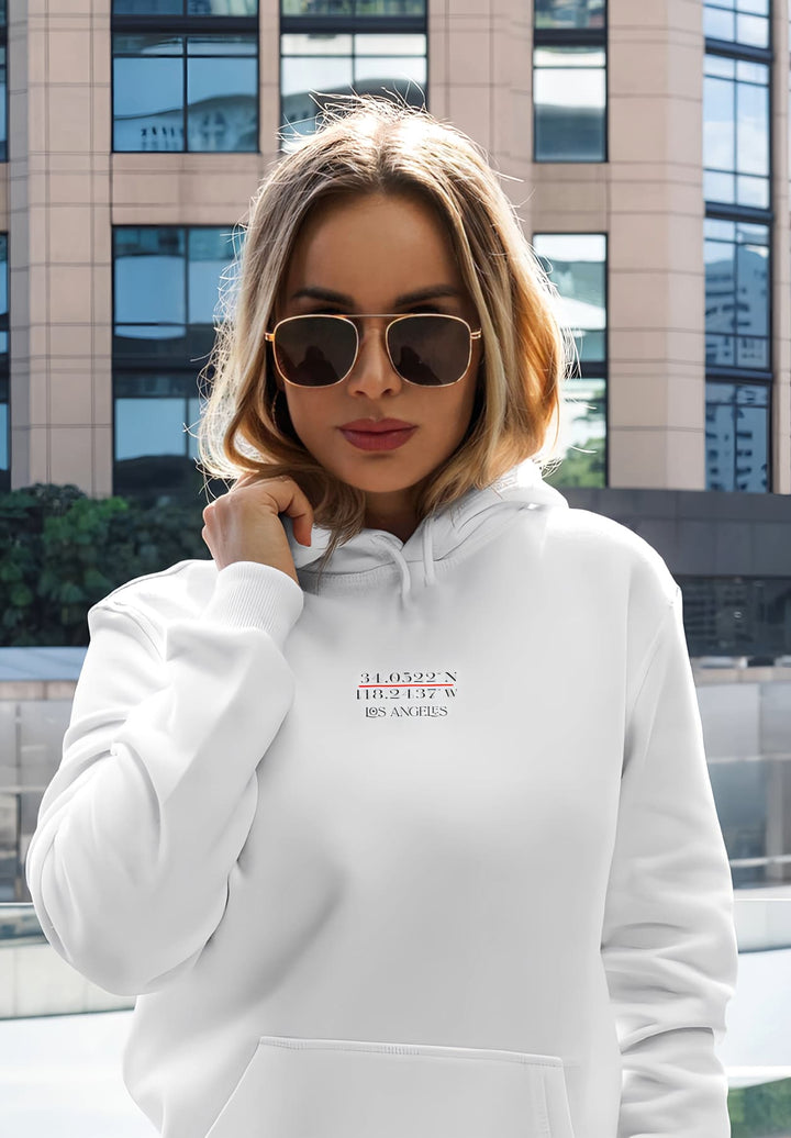 The white hoodie and sunglasses give a casual, trendy look.