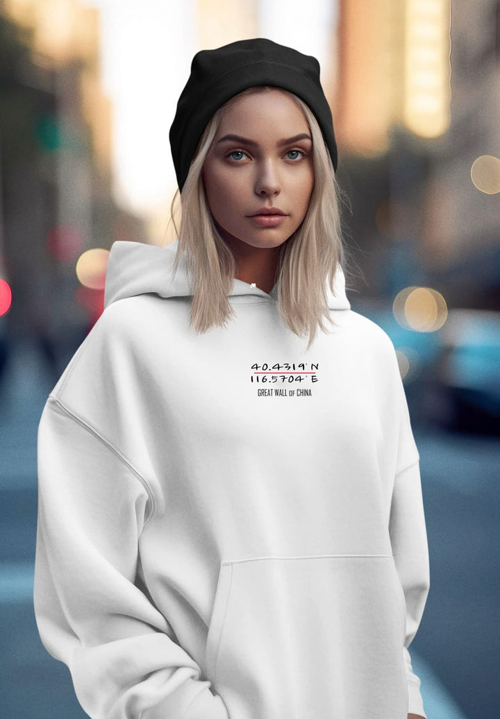 The young women project a unified image of contemporary ease and fashion-forward simplicity in her white pullover hoodie.
