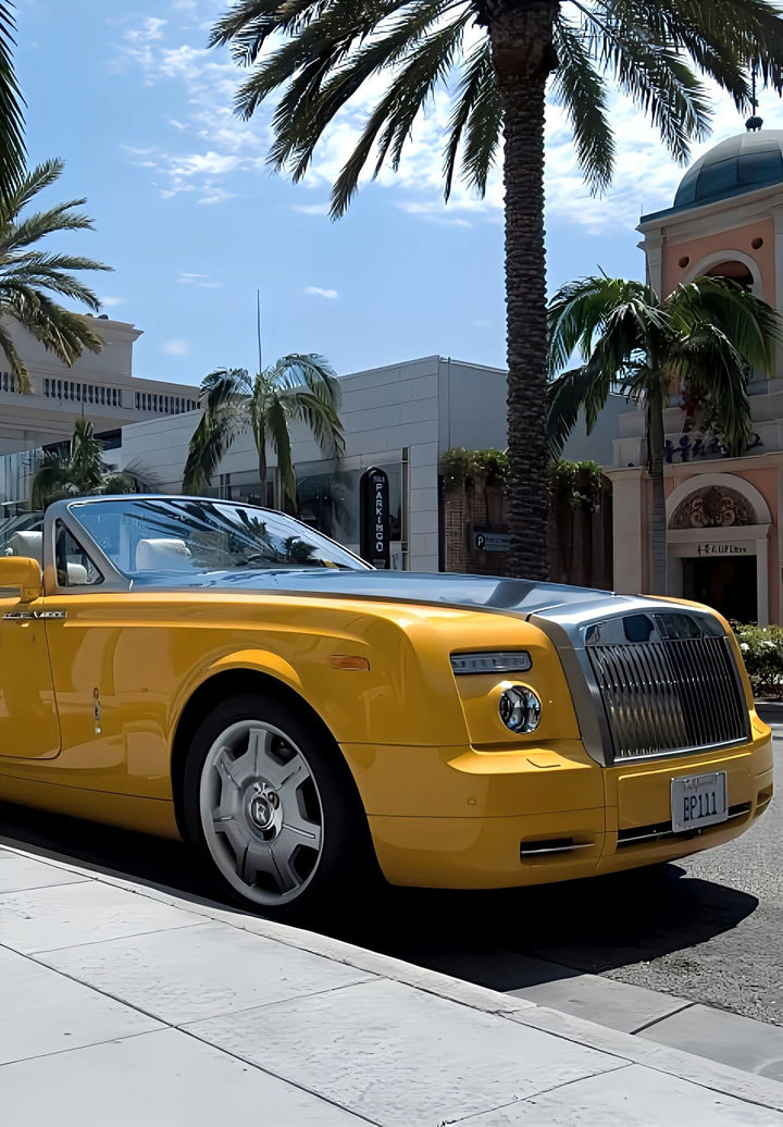 A yellow Rolls Royce is parked in front of the Louis Vuitton store on Beverly Boulevard.