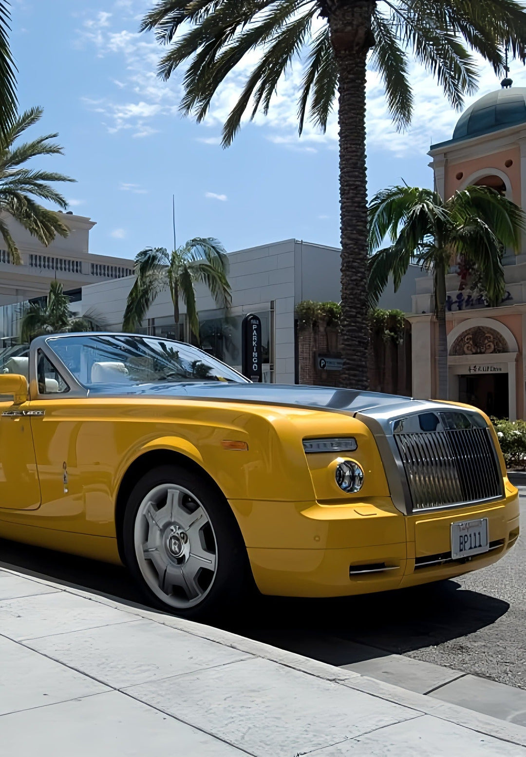 In Beverly Hills, a yellow Rolls Royce is parked outside in front of Louis Vuitton store.