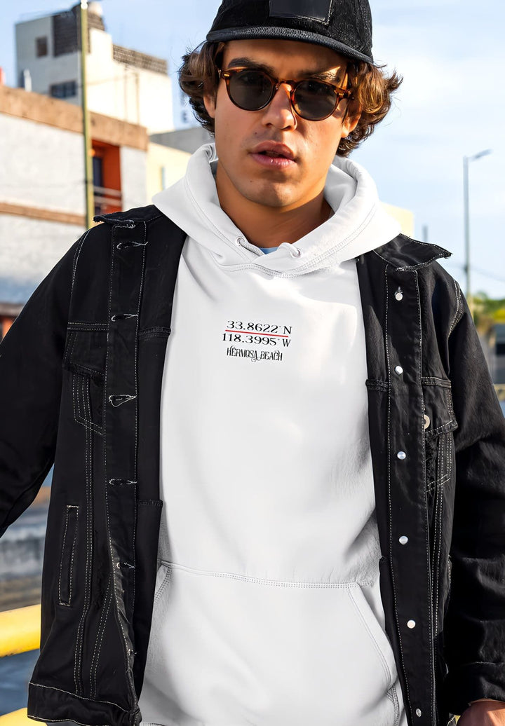 A young man wearing a black hat and sunglasses with a white hoodie streetwear.
