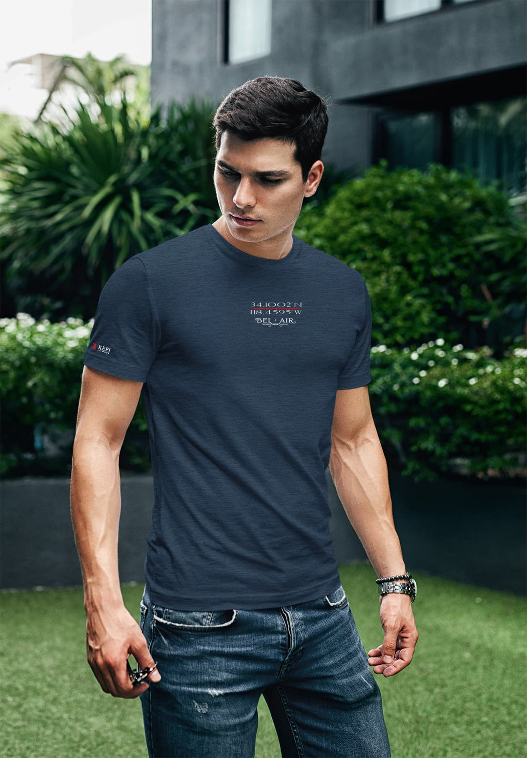 In the calm embrace of nature, a young man stands tall in a dark blue t-shirt, expressing quietness and harmonizing with his natural setting.