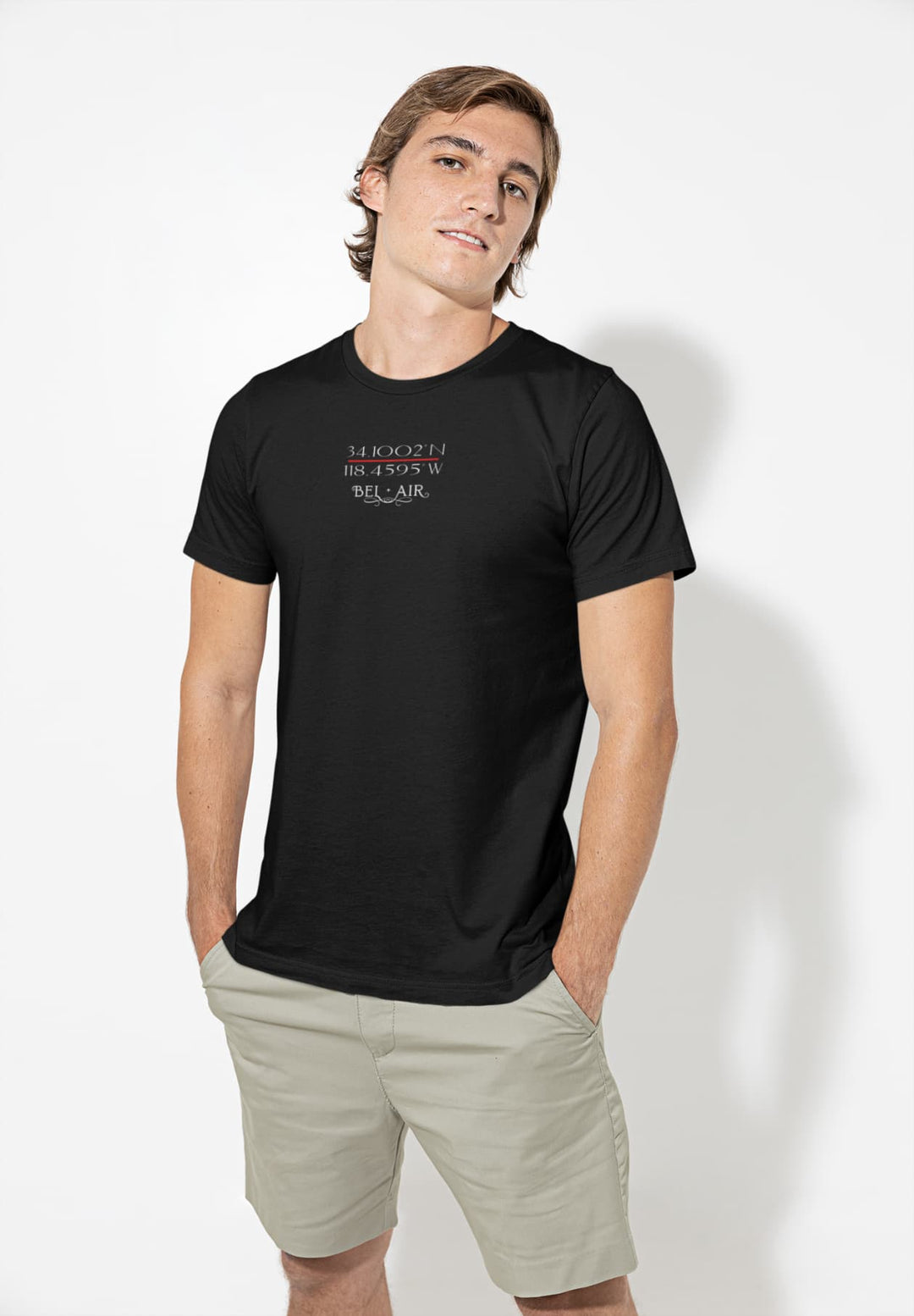 A youthful gentleman embodies effortless calm while modeling a black t-shirt and beige shorts, thereby exuding casual style.