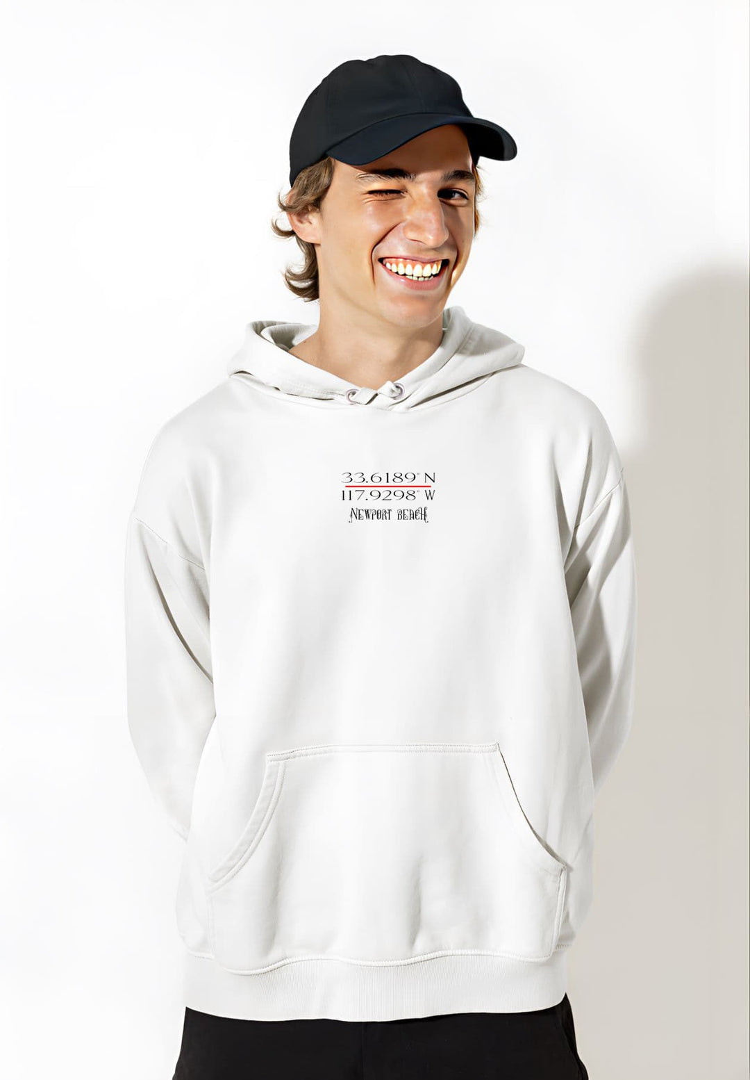 Sporting a white Newport Beach hoodie and a black cap, the young man exudes urban chic and youthful flair.