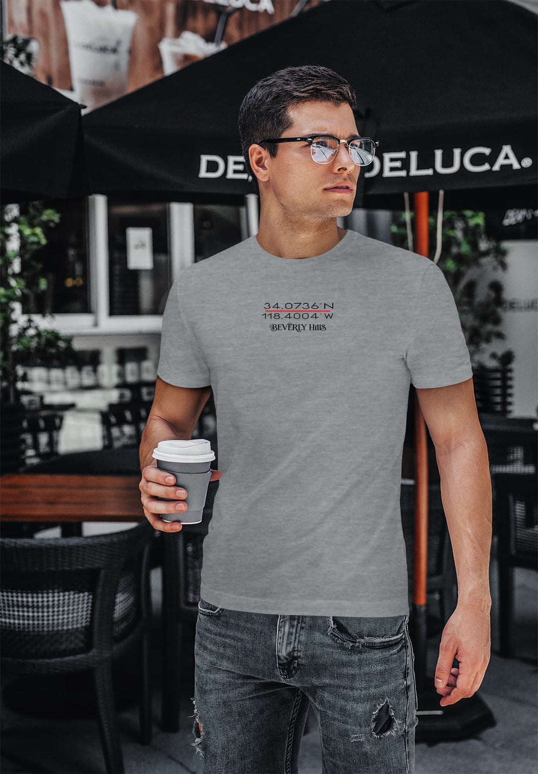  In the stylish feel of Beverly Hills, a young man sips coffee in a gray tee, embracing the Californian outdoors with style.