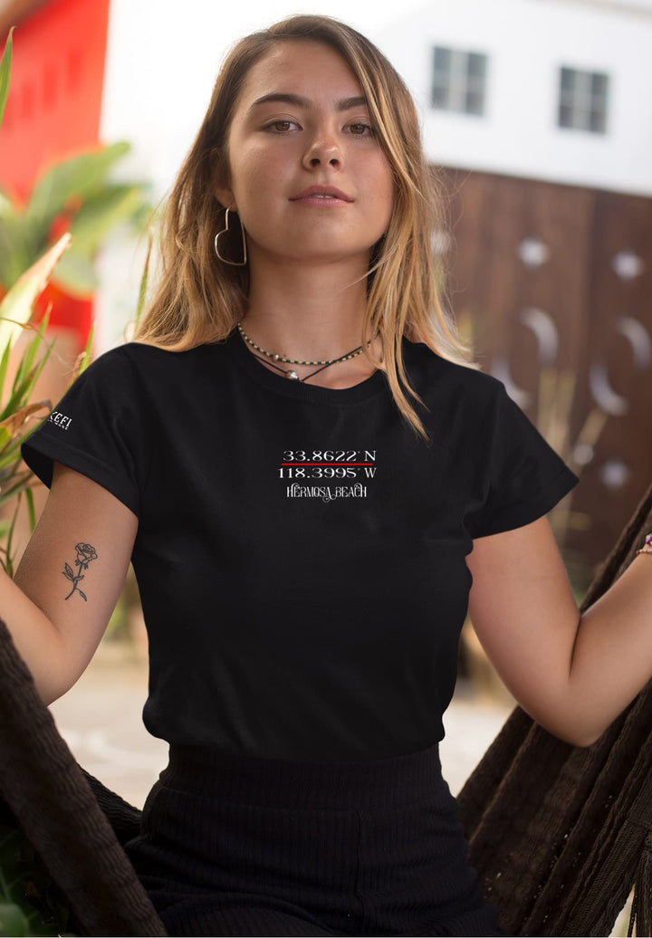 A young woman seated with a delightful blend of nature and fashion, while wearing a chic black t-shirt, seamlessly merging contemporary style with a touch of beauty.